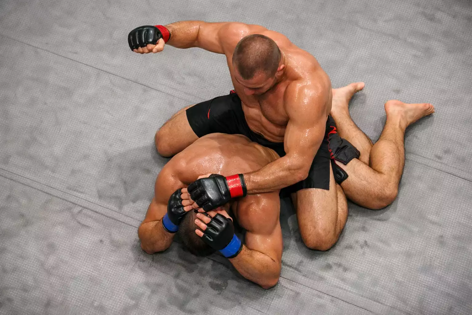 Wrestler kontrolliert Gegner am Boden mit dominanter Position